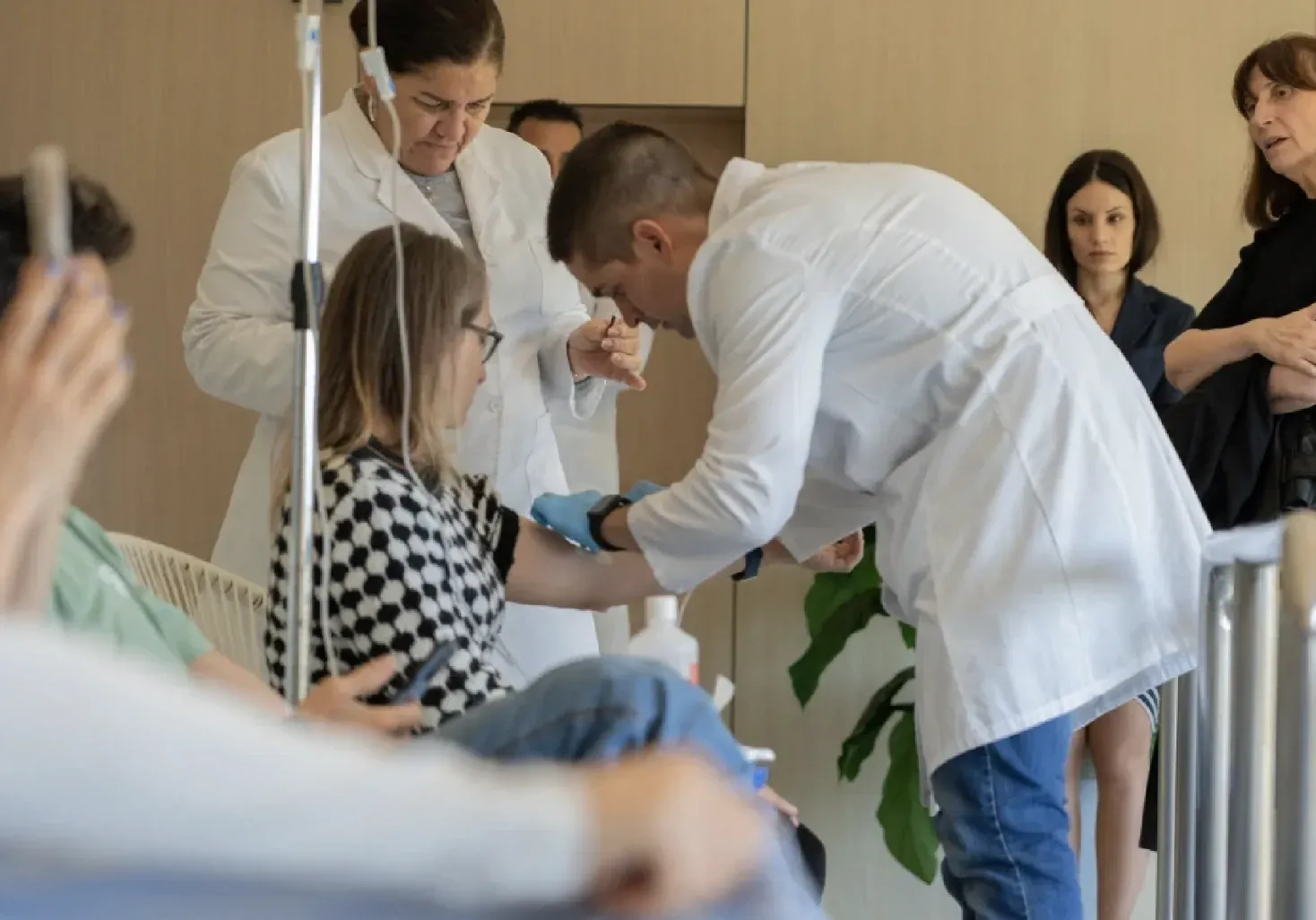 Clinical team preparing an intravenous line during a medical session