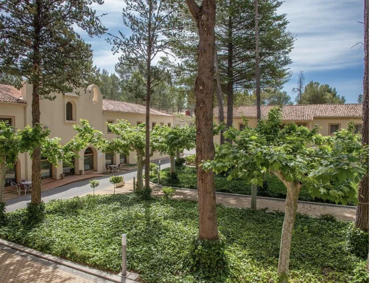 Edificios de alojamiento integrados entre árboles y jardines